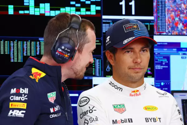 Foto de Checo Pérez con gesto incómodo hablando con un ingeniero en el garage de Red Bull del GP de Austria 2024.