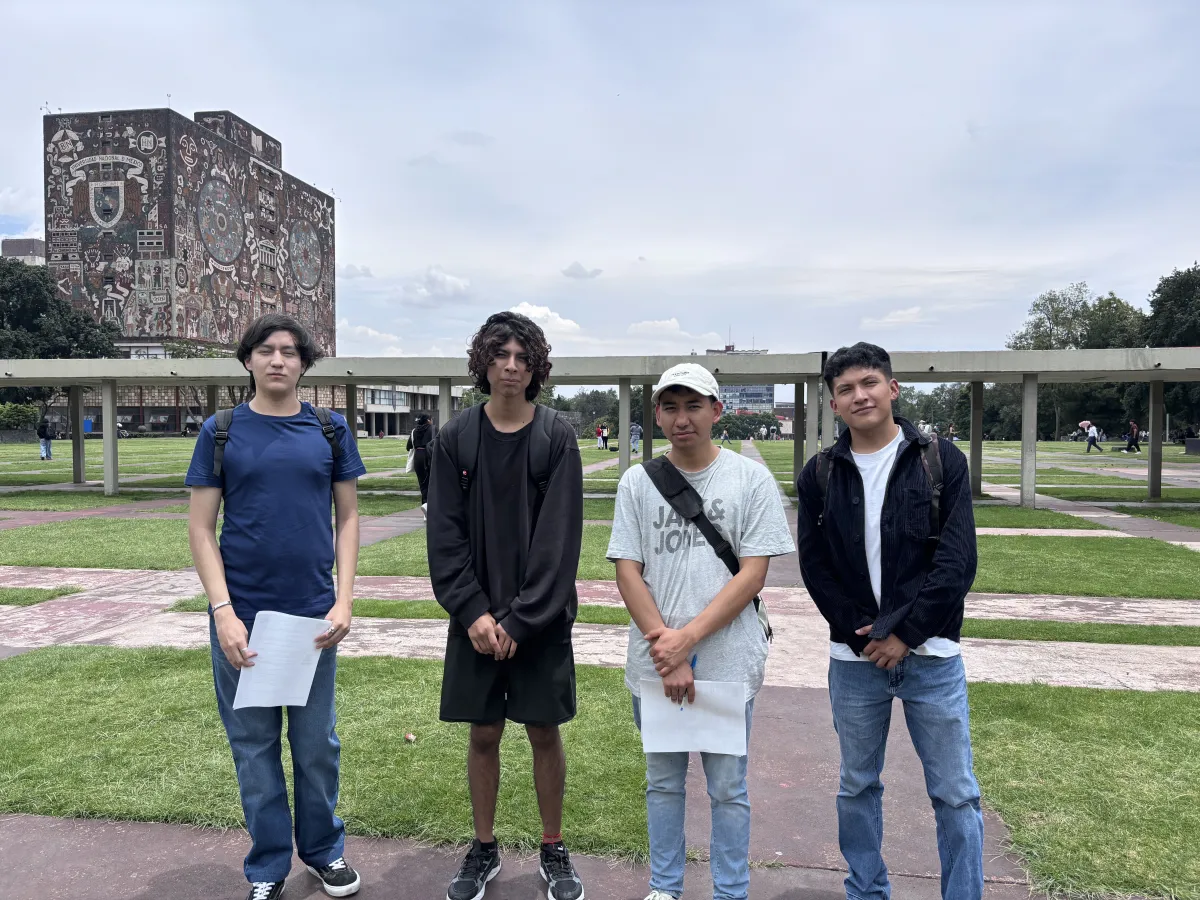 Estudiantes de nuevo ingreso a licenciatura de la UNAM posan en el campus de Ciudad Universitaria frente a la Biblioteca Central.