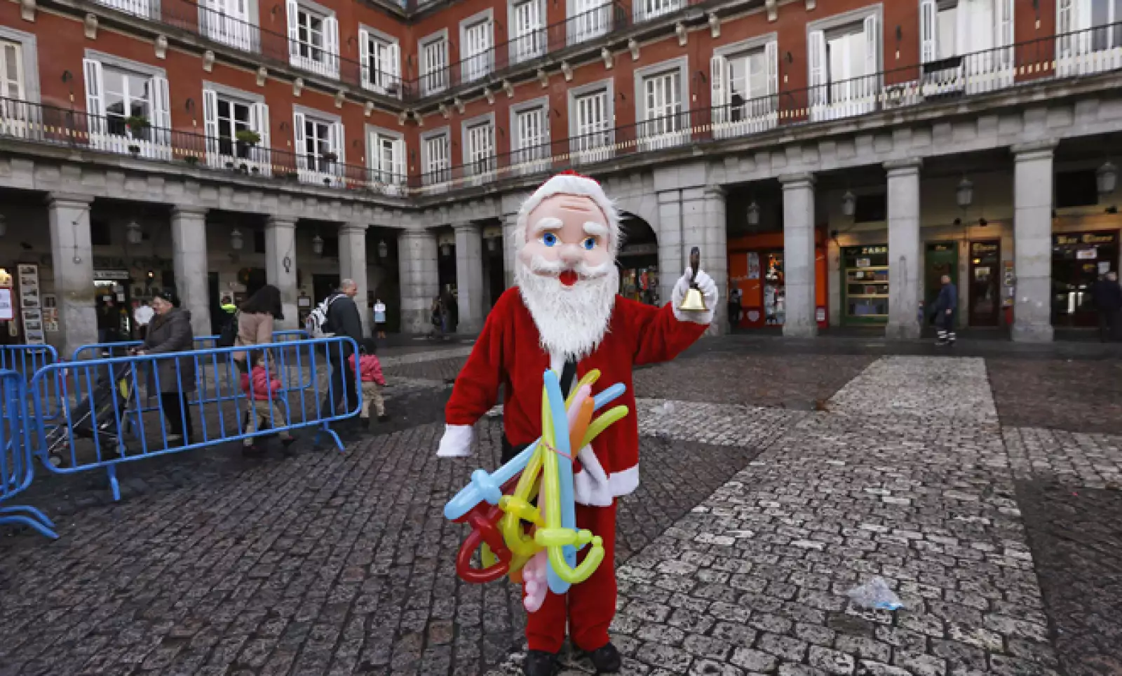 En una plaza de Madrid, España, un hombre se viste de Santa Clos para vender globos.
