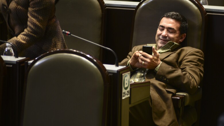 Este diputado fue captado muy sonriente revisando su celular.