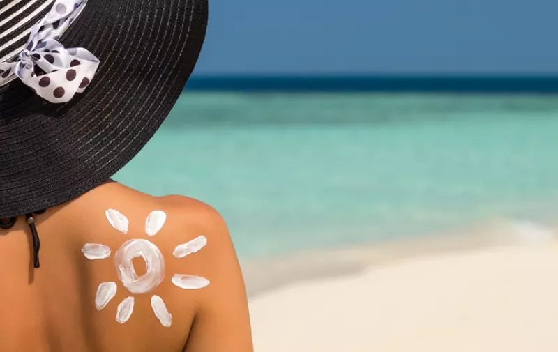 Woman with sun-shaped sun cream