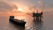 Un buque petrolero al lado de una plataforma, en medio del mar. 