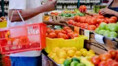 Unrecognizeable customer talks with the supermarket employee