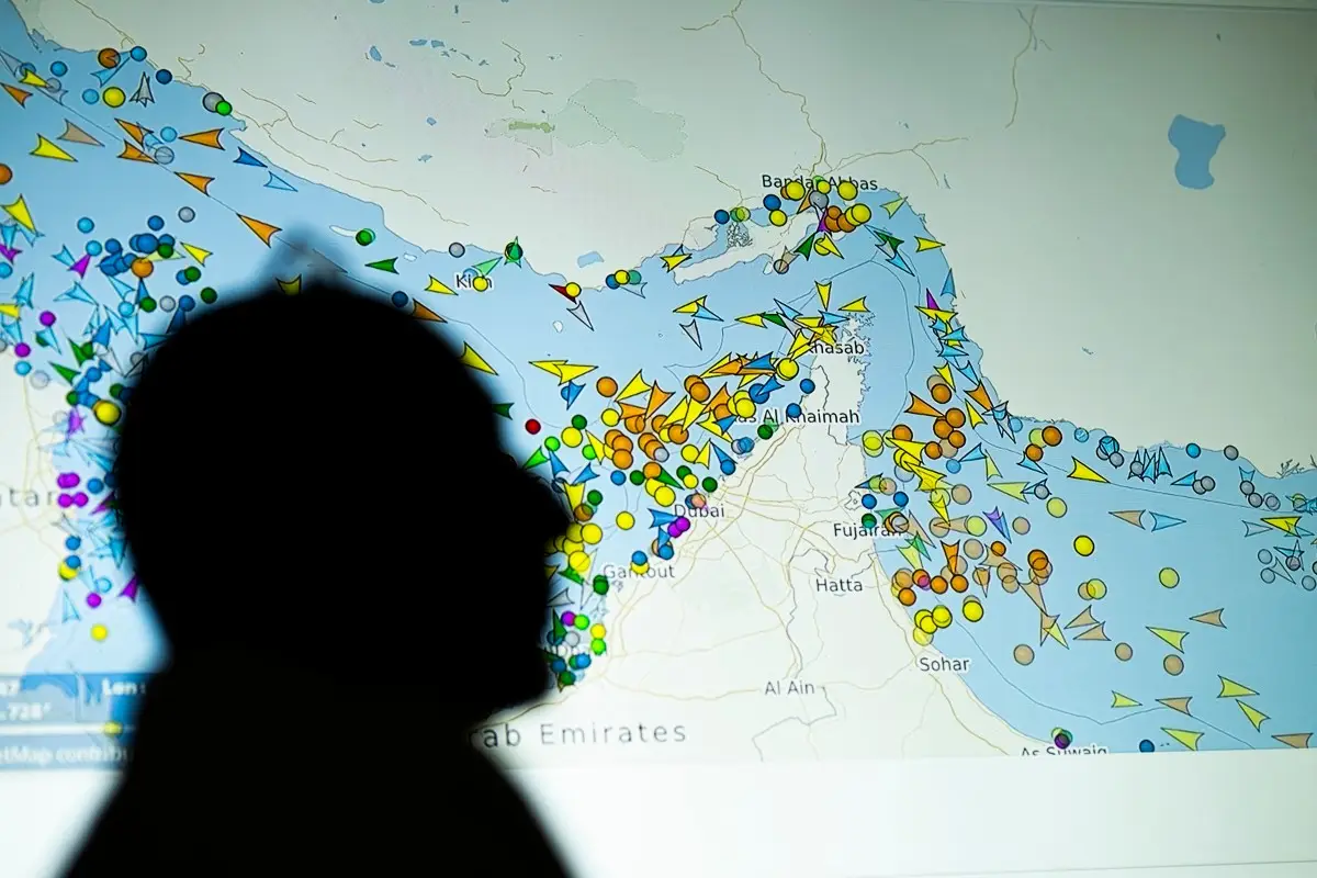 Una ilustración fotográfica tomada en Nicosia el 4 de mayo de 2026, muestra a una persona frente a una gran pantalla que muestra los movimientos de los buques en el Estrecho de Ormuz en un sitio web de seguimiento de buques. Teherán anunció que estaba cerrando el Estrecho de Ormuz el 12 de julio y lanzó misiles y drones a sus vecinos del Golfo, en represalia por los nuevos ataques estadounidenses después de un ataque de las fuerzas iraníes a un buque mercante que fue abandonado en llamas por su tripulación.