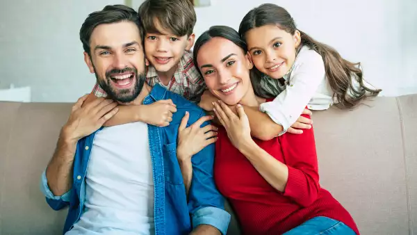 Young happy family relax together at home smiling and hugging