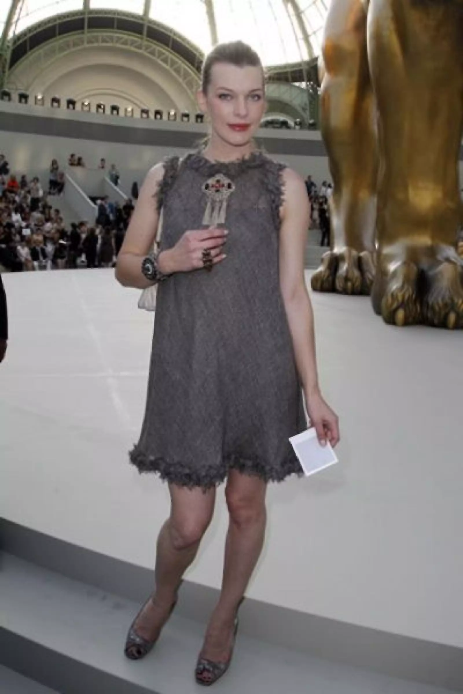 Mila Jovovich, con un mini vestido gris y labios rubí, también estuvo en primera fila.