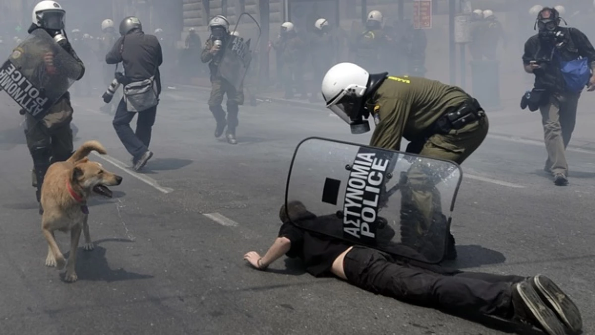 un policia detiene a un manifestante griego