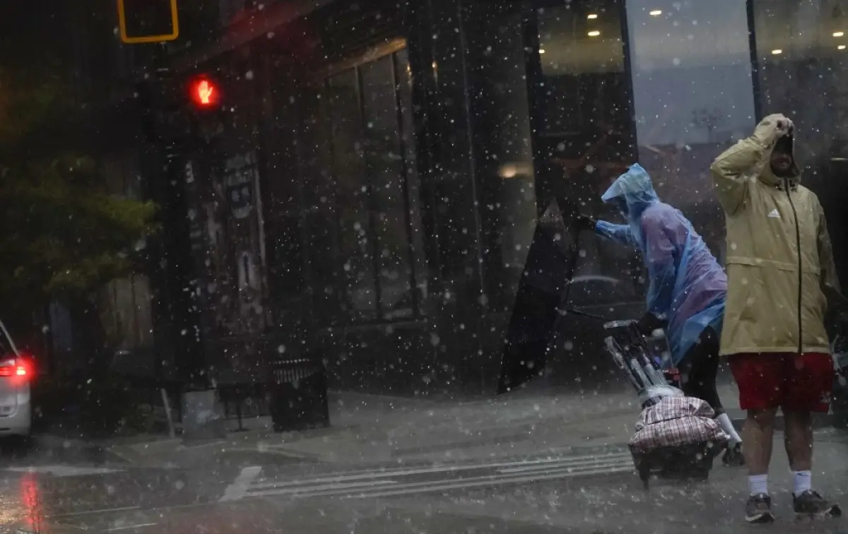 Un paraguas es volado al revés cuando una persona cruza la calle durante una tormenta en Washington, DC, el 7 de agosto de 2023. Una vigilancia de tornados está en vigor en la zona, con fuertes lluvias, fuertes vientos y granizo.