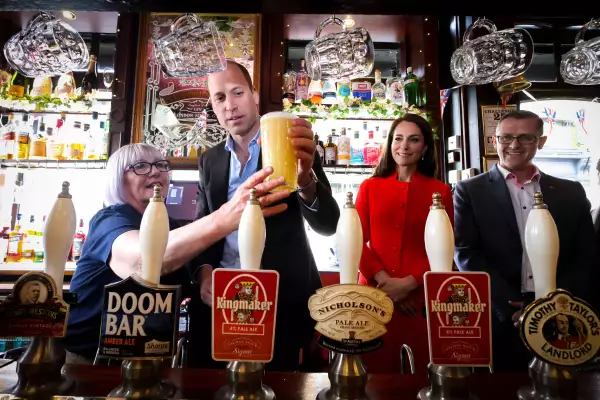 El príncipe William y Kate Middleton en el pub Dog and Duck sirviéndose una cerveza con los trabajadores del lugar. 