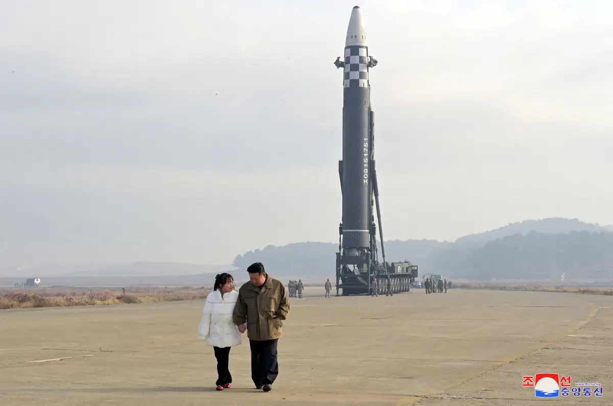 FILE PHOTO: North Korean leader Kim Jong Un, along with his daughter, walks away from an ICBM in this undated photo released by KCNA