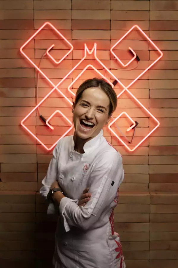 Chef Ana Martorell posando alegremente enfrenete de unas luces LED 