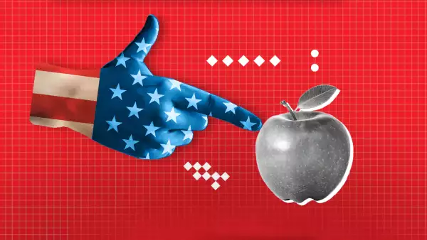 Una mano pintada como la bandera de Estados Unidos apunta a una manzana. 