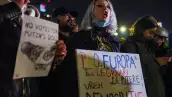 Una mujer sostiene un cartel que dice "Pro-Europa" y "Queremos democracia" mientras corea consignas durante una protesta contra Calin Georgescu, el candidato independiente a la presidencia rumana que llegó a la es elecciones, en Bucarest, Rumania, el 27 de noviembre de 2024.