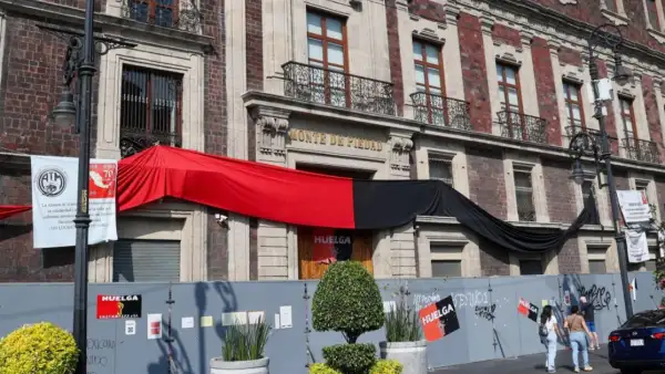 Sucursal de la Ciudad de México de Nacional Monte de Piedad cerrada y bardeada, con banderas rojas y negras colocadas por los trabajadores que se mantienen en huelga desde el 1 de septiembre de 2025.