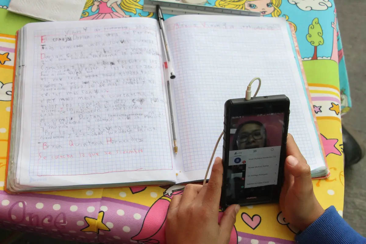 Un estudiante utiliza un celular para tomar clases.