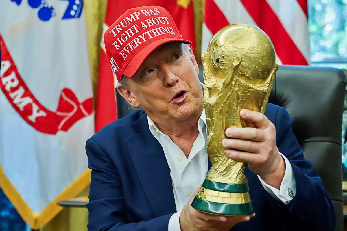 El presidente de Estados Unidos, Donald Trump, lleva un sobre que dice  "¡Trump tenía razón sobre todo!" y sostiene el Trofeo de la Copa Mundial de la FIFA, mientras hace un anuncio sobre la Copa Mundial de la FIFA 2026, en la Oficina Oval de la Casa Blanca en Washington, D.C., EE. UU., 22 de agosto de 2025.