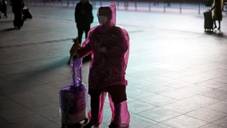 Woman wears face mask and plastic raincoat as a protection from coronavirus in Shanghai