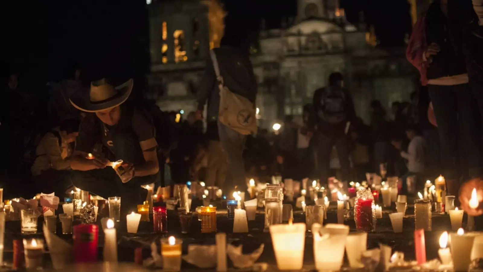 Una persona enciende una de las muchas velas en el Zócalo