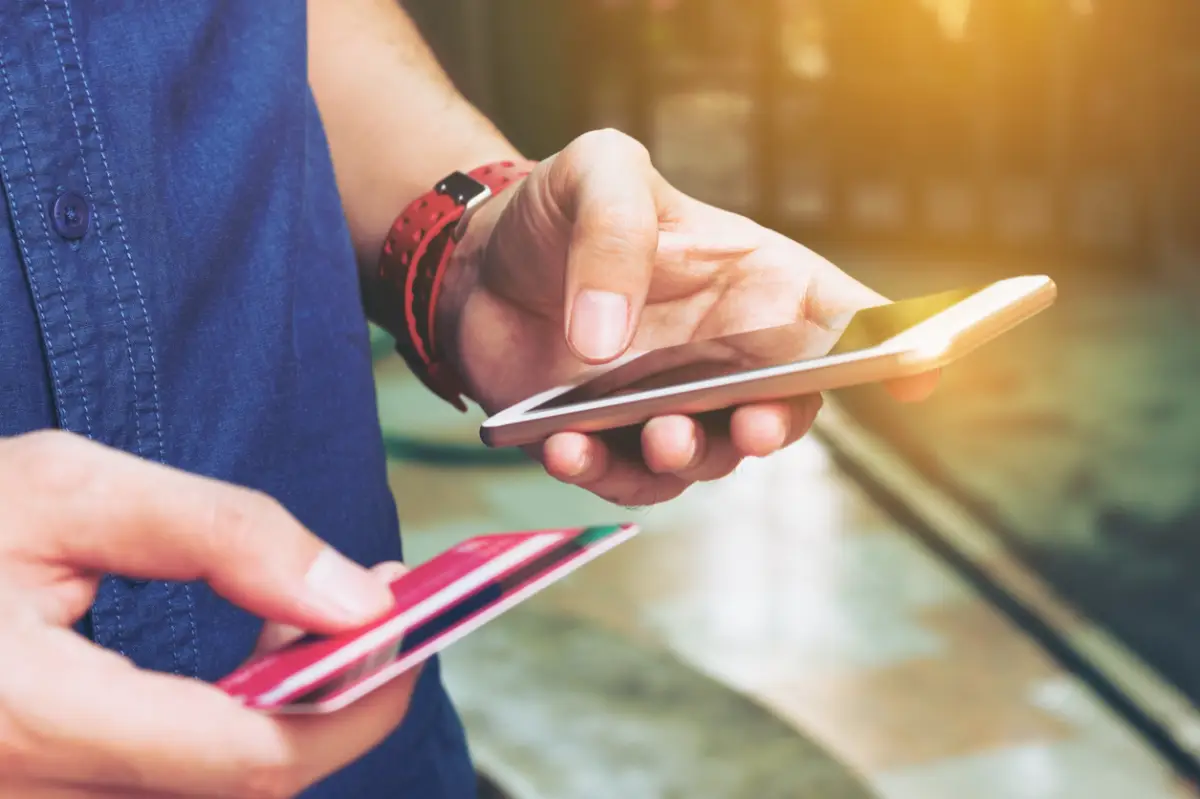 Man use smart phone and holding credit card with shopping