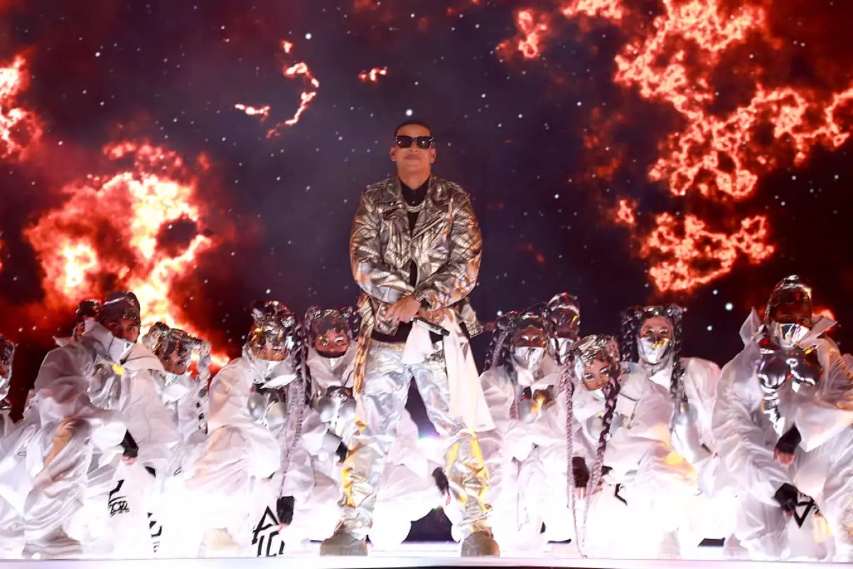 foto de daddy yankee con un traje plat4eado brillante y bailarines detrás durante un concierto en Puerto Rico, 2022.