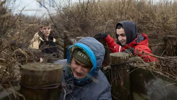 Pavel, Alex y Artur limpian trincheras en una posición militar en la costa del Mar de Azov. El padre Gennady y sus hijos adoptivos limpian trincheras de malezas en la costa del mar de Azov el 18 de febrero de 2022 en Mariupol, Ucrania.