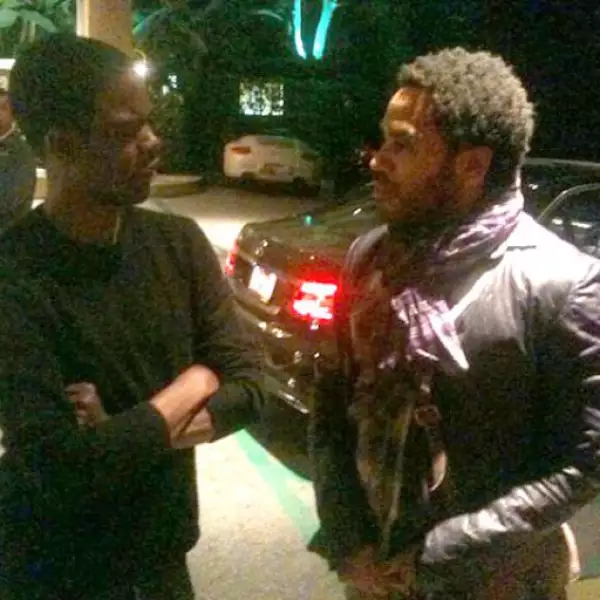 Chris Rock y Lenny Kravitz platicando en la calle.