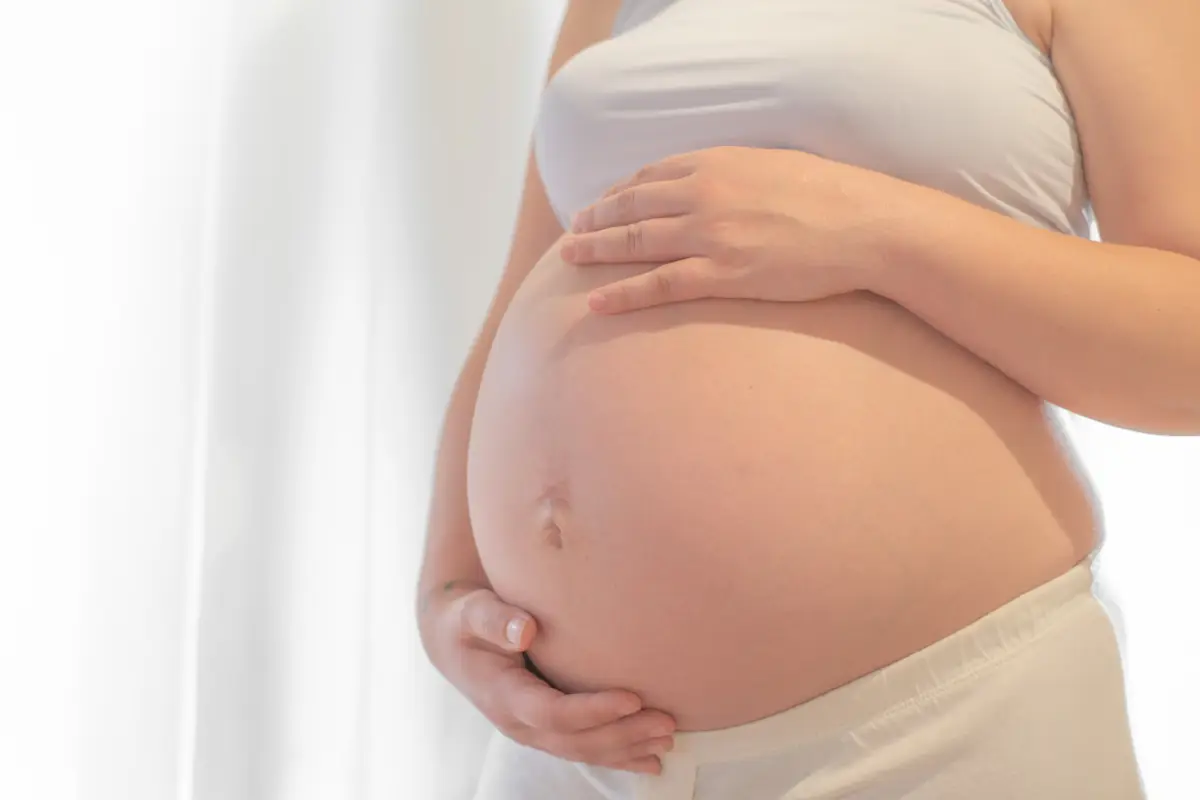 Pregnant woman with hand on belly.