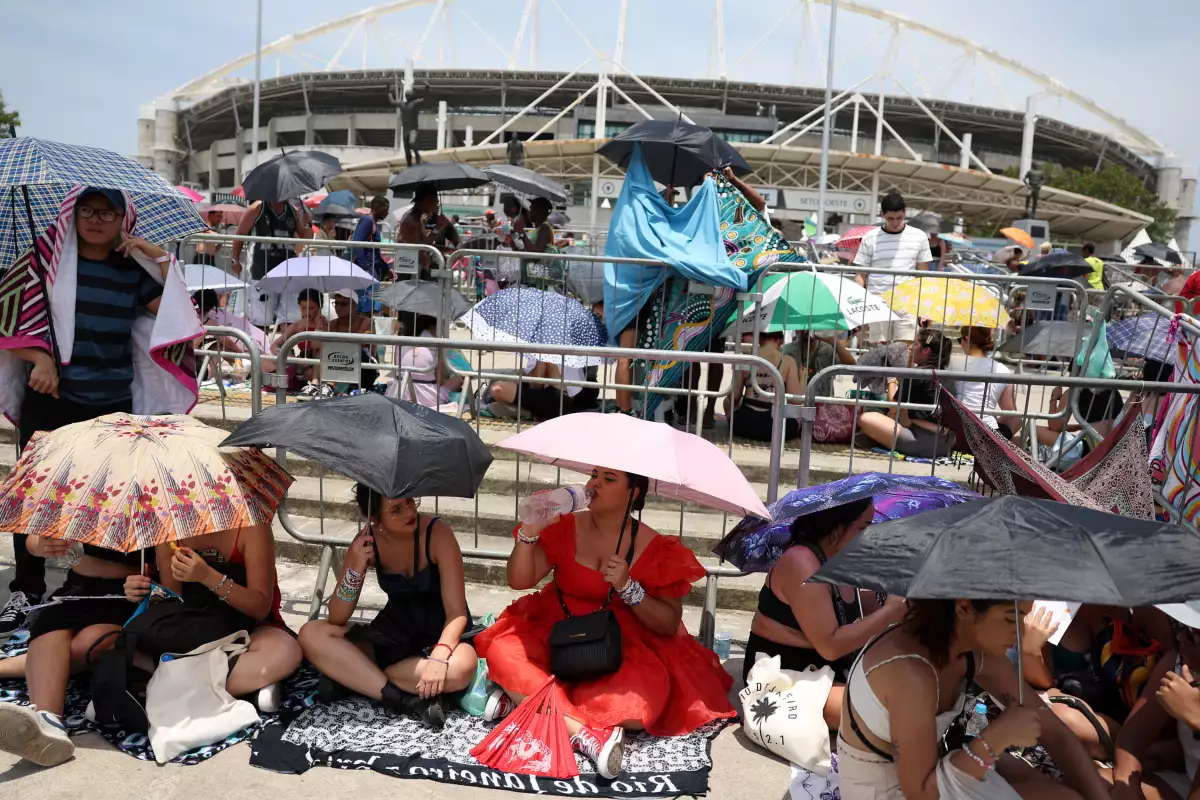 La gente con paraguas espera el concierto de Taylor Swift, tras la muerte de un fan debido al calor durante el concierto del primer día, en Río de Janeiro, Brasil, el 18 de noviembre de 2023.