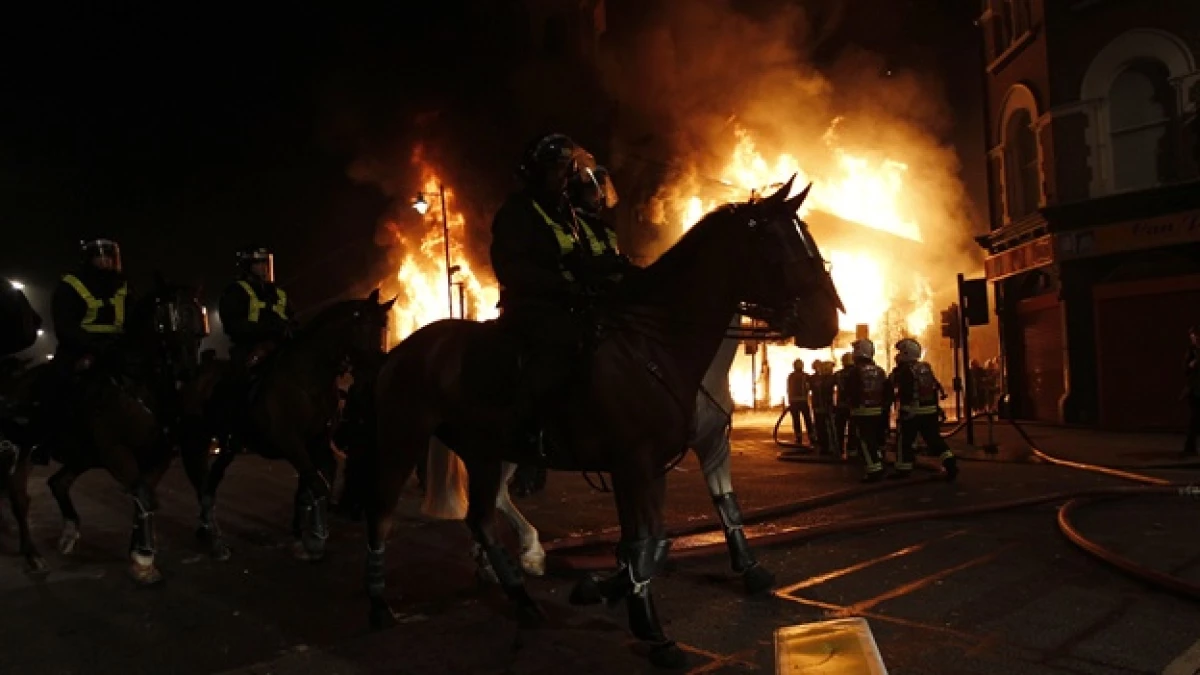 polica montada de londres ante edificio incendiado