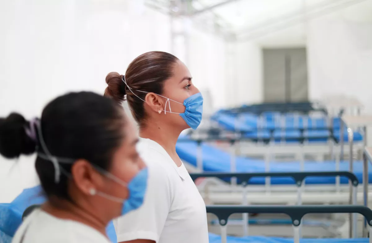 Two nurses wearing protective masks pose inside the new immediate response mobile hospital in Pachuca