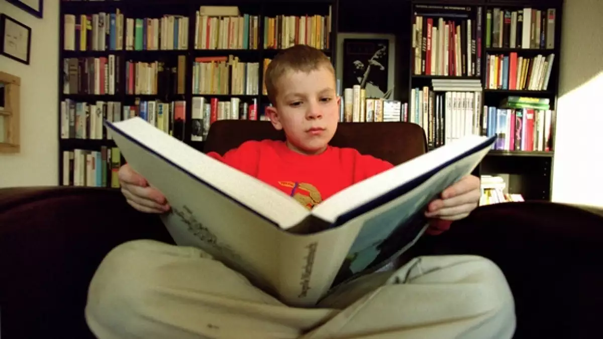 Un menor de edad con problemas de aprendizaje por dislexia trabaja para solucionar su problema, leyendo