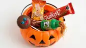 Calabacita naranja de plástico para pedir calaverita, llena con cuatro dulces mexicanos: Paleta Payaso, Conejo Turin, chocolate Carlos V y Pelón Pelo Rico.