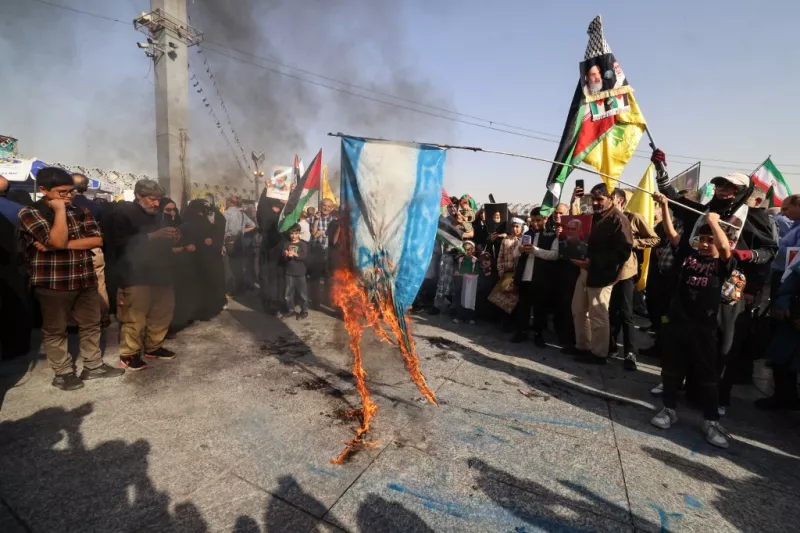 Iraníes queman una bandera israelí durante una protesta en Teheran el 2 de octubre de 2024. 
