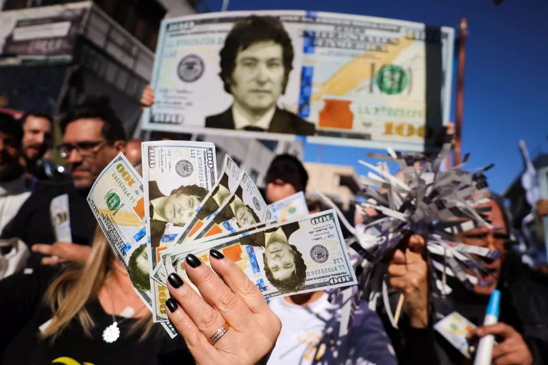 Los partidarios del candidato presidencial argentino Javier Milei sostienen billetes de dólar con la cara sobre ellos, durante un mitin de campaña, en Buenos Aires, Argentina, el 25 de septiembre de 2023.