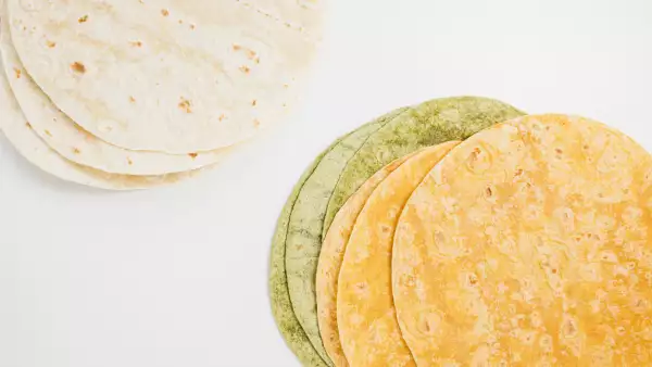 Spanish tomato, spinach flavored and plain wheat tortilla wraps on white background