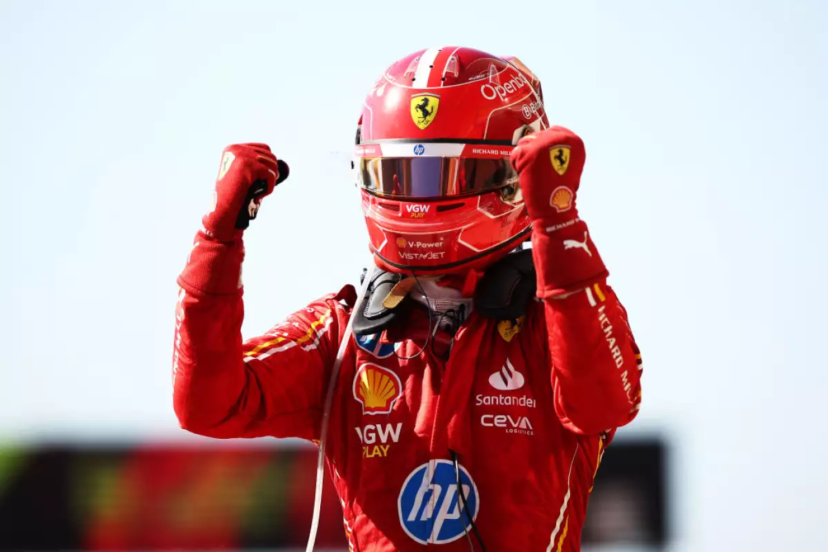 Foto de Charles Leclerc con el casco de Ferrari puesto y levantando los puños al bajar de su auto.