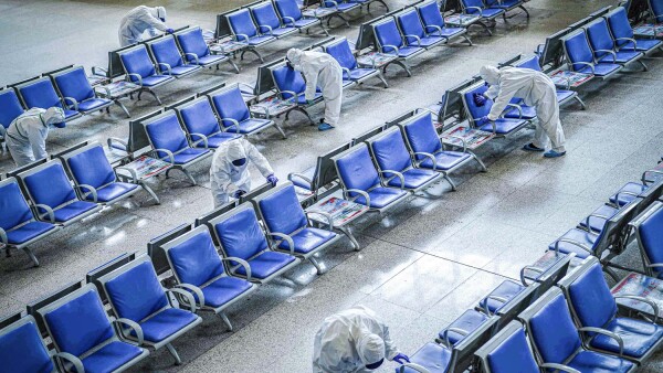 Los trabajadores en trajes de protección desinfectan una sala de espera en la estación de tren de Wuhan que se había cerrado debido al nuevo brote del coronavirus, en Wuhan.