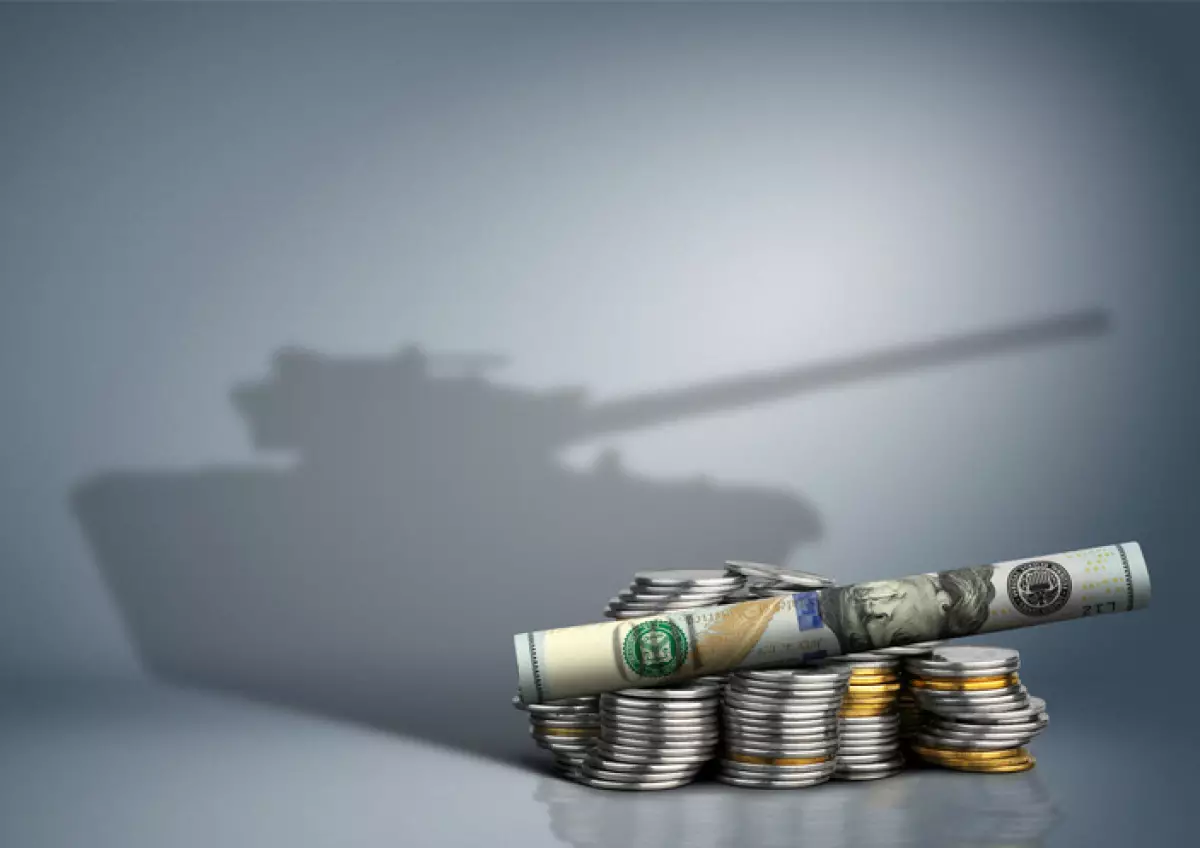 Billetes y monedas con tanque de guerra como sombra