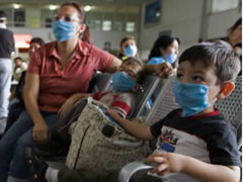 Madre e hijos se protegen del virus de la influenza porcina con tapa bocas. (Foto: Reuters)