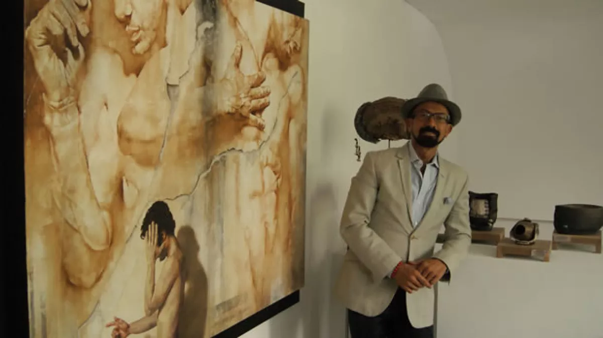Óscar Román y alguna de las obras de arte expuestas en su galería.