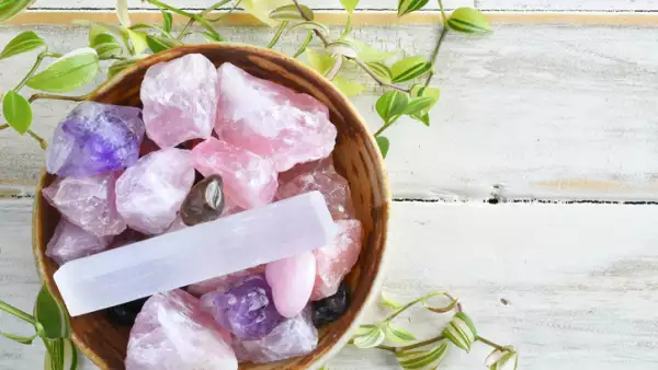 Cuarzos rosas en una canasta con plantas alrededor 
