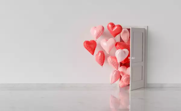 Puerta abierta de la que salen globos de corazones