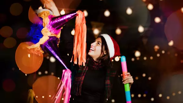 Por qué se celebran las posadas (Mujer sostiene una piñata)