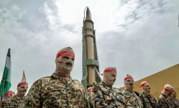 El personal militar del Cuerpo de la Guardia Revolucionaria Islámica (IRGC) desfila bajo un misil balístico iraní Kheibar Shekan en el centro de Teherán durante un mitin que conmemora el Día Internacional de los Quds, también conocido como el Día de Jerusalén, el 29 de abril de 2022.