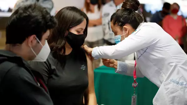 En la imagen, una mujer recibe una vacuna contra la COVID-19 en la CDMX.