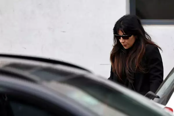 Foto de Gianinna Maradona con lentes oscuros y ropa oscura abordando un auto.