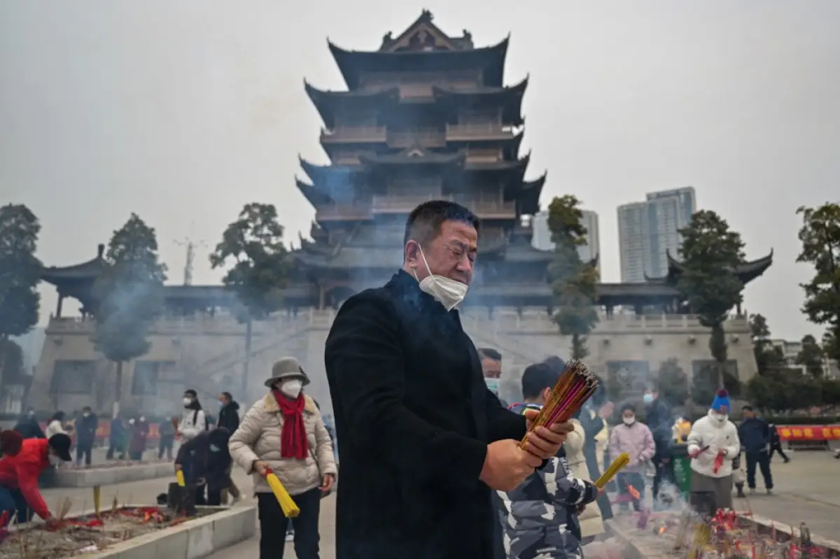 Personas queman varas de incienso en el templo budista de Guiyuan en Wuhan, en la provincia central de Hubei de China. 