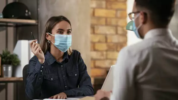 Una mujer entrevista a un candidato para oferta de trabajo. 