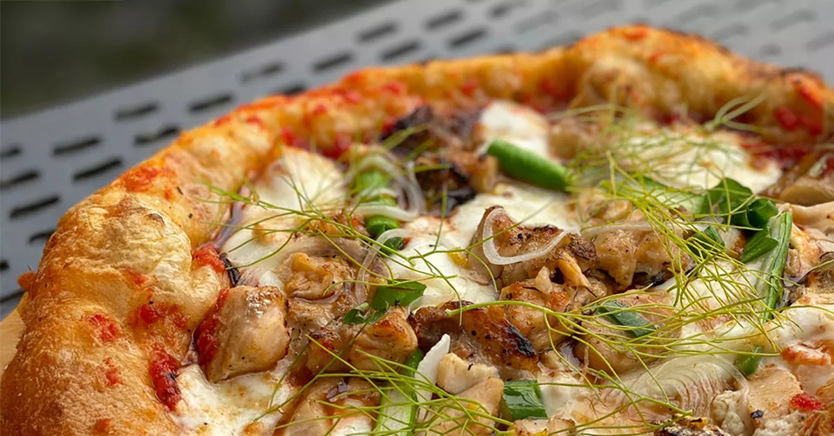 Una mujer está acomodando la mesa para una pizza party del Abierto mexicano de pizza 