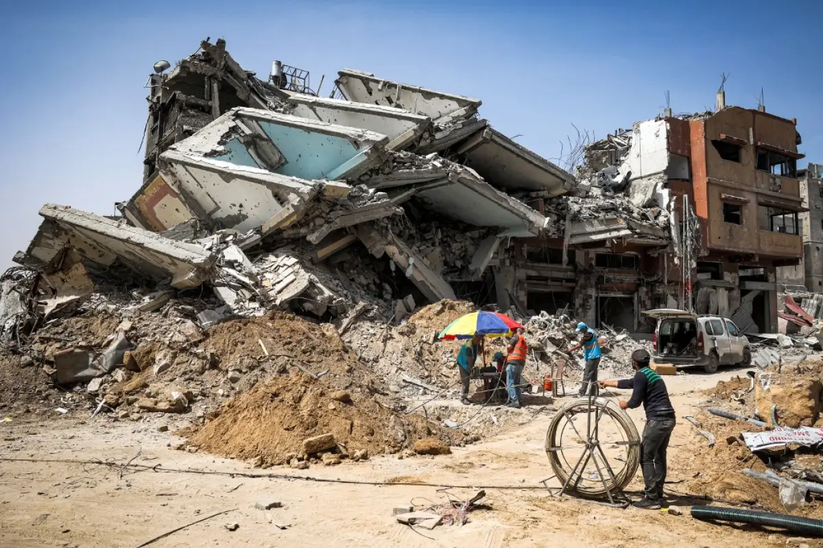 Trabajadores de salvamento operan en el lugar de un edificio destruido en Khan Yunis, en el sur de la Franja de Gaza, el 22 de abril de 2024, en medio del conflicto en curso en el territorio palestino entre Israel y el grupo militante Hamás.